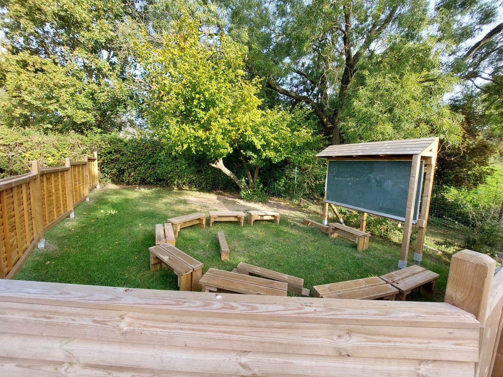 La classe en plein air avec ses bancs en bois et son tableau