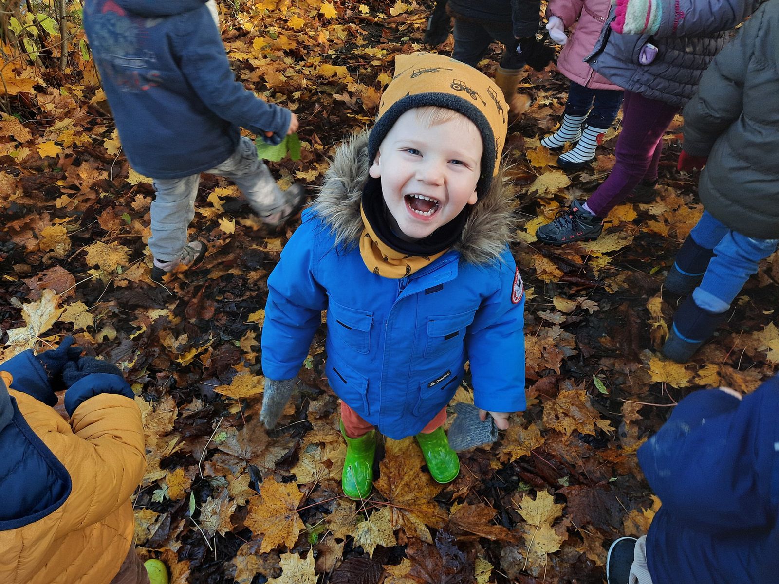 Un enfant éclate de rire dans les feuilles d'automne
